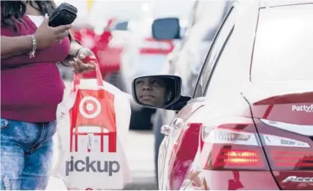  ?? ROGELIO V. SOLIS/AP ?? A Target employee prepares to hand a customer a curbside pickup purchase Nov. 5 in Jackson, Mississipp­i.