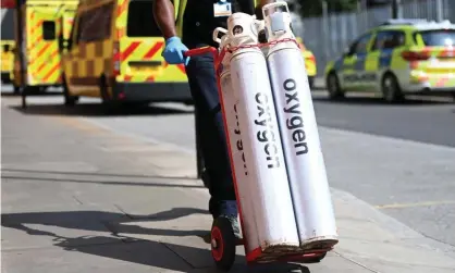  ??  ?? Hospital staff move oxygen tanks outside the Royal London hospital last Friday. Photograph: Andy Rain/EPA