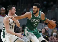  ?? ?? DEFENSE. Milwaukee Bucks' Pat Connaughto­n (24) defends against Boston Celtics' Jayson Tatum (0) during the first half of an NBA basketball game Friday, Nov. 12, 2021, in Boston. (AP)