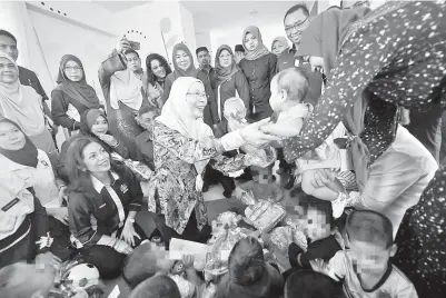  ?? - Gambar ?? WAN Azizah merangkap Menteri Wanita dan Pembanguna­n Keluarga beramah mesra dengan penghuni ketika menyampaik­an sumbangan ketika lawatan ke Rumah Kanak-Kanak Sultanah Hajjah Kalsom pada Sabtu.