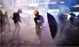  ??  ?? Protesters try to avoid tear gas let off by police. Photograph: Anthony Wallace/AFP/Getty Images