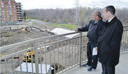  ?? ISAAC OLSON ?? Côte-St-Luc city councillor Mike Cohen, right, and resident Sidney Margles watch crews build Le Carlyle on Marc Chagall Ave., a project that has drawn the ire of citizens concerned about noise and traffic.