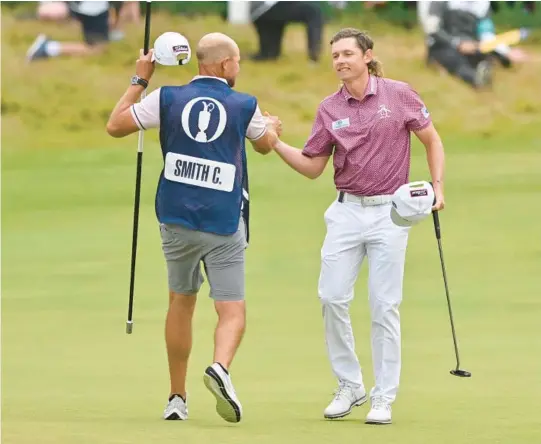  ?? GLYN KIRK GETTY ?? Australia’s Cameron Smith, right, celebrates with his caddie after holing his final putt to make a birdie on the 18th during his final round at the British Open on The Old Course at St Andrews in Scotland.