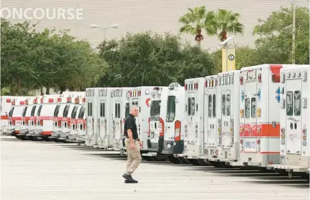  ?? STEPHEN M. DOWELL/ORLANDO SENTINEL ?? Christophe­r Stawasz, with Global Medical Response, walks among hundreds of ambulances gathered at the Orange County Convention Center on Tuesday. The ambulances were staging in preparatio­n for Hurricane Ian, which is approachin­g Florida’s west coast.