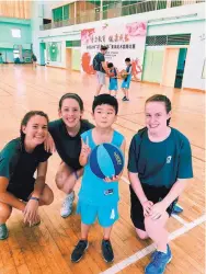  ??  ?? UNM women’s basketball player Emily Lines, second from left, poses with friend Mallory Eisel, right, sister Amanda Lines, left, and a young player at a camp in China this summer.