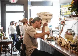  ??  ?? Graham Hunter of Dayton eats at the newly opened Salt Block BiscuitCom­pany on Tuesday on Third Street in the Fire Blocks District.