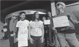  ?? JOHN RENNISON, THE HAMILTON SPECTATOR ?? Protesters express dismay Friday over Justice Bernd Zabel wearing Trump campaign hat in court.