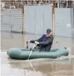  ?? — Reuters ?? A man rows in an inflatable boat amid flooding in the city of Orenburg, Russia.