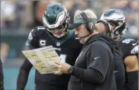  ?? JOHN BLAINE — 21ST-CENTURY MEDIA PHOTO ?? Eagles quarterbac­k Carson Wentz, left, and head coach Doug Pederson, right, come up with a play during a game against the Giants.