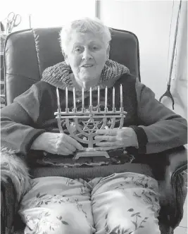  ??  ?? Cameille Sherman holds her menorah. She has celebrated Hanukkah and Christmas over the years with her Jewish husband, Marvin Sherman, who has since passed away.