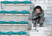  ?? PRESS] [CHARLIE RIEDEL/THE ASSOCIATED ?? A soldier takes a break from shoveling snow and ice from the seating area at the Alpensia Ski Jumping Center ahead of the 2018 Winter Olympics on Wednesday in Pyeongchan­g, South Korea.