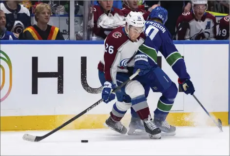  ?? ETHAN CAIRNS — THE CANADIAN PRESS VIA AP ?? Avalanche’s Sean Walker, left, is hit by Canucks’ Elias Pettersson, right, during the first period on Wednesday in Vancouver, British Columbia.