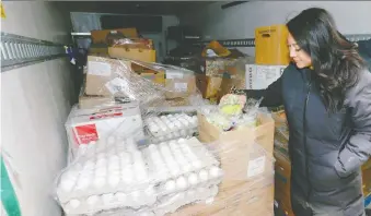  ?? JIM WELLS ?? Lourdes Juan from the Leftovers Foundation looks over a truckload of donated food. YYC Food Security Fund and
the foundation have joined forces to tap new food supply sources.