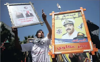  ?? PICTURE: REUTERS ?? Demonstrat­ors hold pictures of jailed Palestinia­ns during a rally in Gaza City in support of prisoners on hunger strike in Israeli jails.
