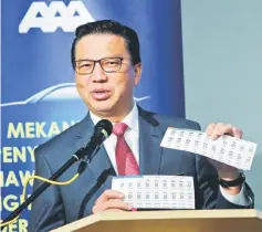  ??  ?? Liow showing the QR code at the Transport Ministry in Putrajaya. — Bernama photo