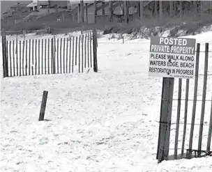  ?? Associated Press ?? ■ This May 15 photo shows a sign at the edge of a public beach marking where private beaches begin in Santa Rosa Beach, Fla. A new Florida law is set to reignite a fight over beach access in a Florida Panhandle county known for its pristine,...