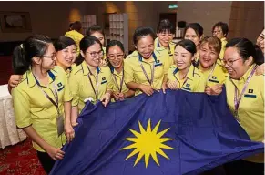  ??  ?? All smiles: MCA members who are in charge of carrying the party flag at the Wanita MCA AGM sharing a light moment together.