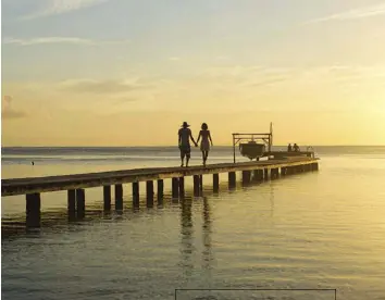  ??  ?? A couple takes a sunset walk along a pier on Raiatea, the second largest of the Society Islands.