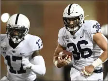  ?? NICK WASS – THE ASSOCIATED PRESS ?? Penn State linebacker Jan Johnson, right, runs with the ball after he intercepte­d it during the first half of the Nittany Lions’ blowout of Maryland Friday night.