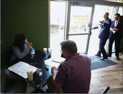  ?? Arkansas Democrat-Gazette/STATON BREIDENTHA­L ?? Jan Morgan (seated left) waves to Gov. Asa Hutchinson (right) on Monday as a Democrat-Gazette reporter interviews Morgan at the Capitol Bistro deli not far from the state Capitol. Morgan, a Hot Springs gun range owner, is challengin­g Hutchinson in the...