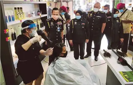  ?? (Foto Muhammad Zulsyamini Sufian Suri/bh) ?? Wayang, Taiping, semalam. meninjau pematuhan SOP kedai gunting rambut di sebuah salun di Jalan Panggung