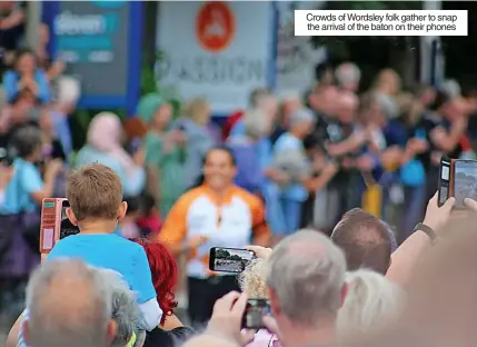  ?? ?? Crowds of Wordsley folk gather to snap the arrival of the baton on their phones