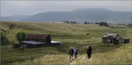  ?? AP PHOTO/DAN ELLIOTT ?? In this Aug. 11, 2017, file photo, visitors approach a former ranch house and barn during a guided hike on the Rocky Flats National Wildlife Refuge near Denver.