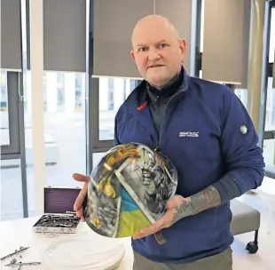  ?? ?? Creative David Crossley has adapted his former profession as a tattoo artist to create an airbrushed helmet in tribute to those suffering due to the war in Ukraine