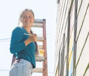  ??  ?? Claire Cashmareck smiles as she paints a mural Wednesday in Bangor.