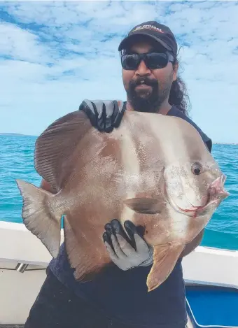  ??  ?? James Durilla with a bat fish caught off Groote Eylandt
