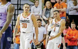  ?? BRYAN TERRY, THE OKLAHOMAN] [PHOTOS BY ?? Oklahoma State’s Kendall Smith, right, reacts after a foul beside Jeffrey Carroll during a game against Kansas State at Gallagher-Iba Arena in Stillwater on Wednesday.