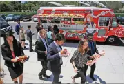  ?? AP PHOTO BY DAMIAN DOVARGANES ?? In this Friday, June 8, photo customers get their lunch at the Japanese food truck Okamoto Kitchen in Beverly Hills.