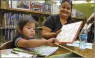  ?? PHOTO BY KEITH DURFLINGER — SAN GABRIEL VALLEY TRIBUNE — SCNG ?? Reyna Luna, 4, and her mother, Diana Rios, read books as they participat­e in the summer reading program at the Covina Public Library.