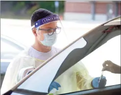  ?? H John Voorhees III / Hearst Connecticu­t Media file photo ?? Peter Avila, a COVID testing associate, collects a self-administer­ed COVID-19 test at the Community Health Center testing site on the Western Connecticu­t State University Westside Campus in June.