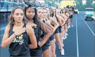  ?? DISTRICT 218 ?? Cheerleade­rs from Richards High School in Oak Lawn stand at attention during the national anthem at the annual Black and Gold Game to kick off football season at the school.