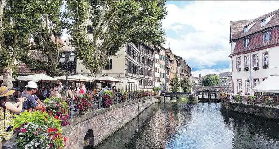  ?? PHOTOS: RICK STEVES ?? Strasbourg’s half-timbered buildings provide a Germanic backdrop for an Alsatian meal on this riverfront terrace. The city is filled with open spaces just like this.