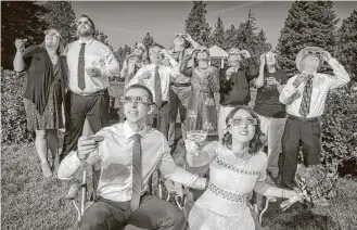  ?? Colin Mulvany / Spokesman-Review via AP ?? After their wedding ceremony, groom and bride, Nathan Mauger, Connie Young with family and friends, toast to the solar eclipse from the Rose Garden in Manito Park in Spokane, Wash.