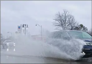  ?? (Arkansas Democrat-Gazette/Colin Murphey) ?? A vehicle splashes water into the air after driving though a puddle on JFK Boulevard in North Little Rock after heavy rain fell across the area Monday.