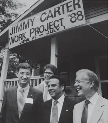  ?? JOE HOLLOWAY JR./ASSOCIATED PRESS FILE PHOTO ?? In 1988, former U.S. president Jimmy Carter poses in Atlanta with Habitat for Humanity founder Millard Fuller, project director Bruce Gunter and then Atlanta mayor Andrew Young in front of a Habitat home.