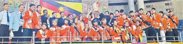  ??  ?? The Sarawak taekwondo team and officials celebratin­g their victory with Minister of Local Government Datuk Dr Sim Kui Hian (12th left) and Salleh (14th right) at the Sarawak Indoor Stadium yesterday.