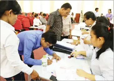  ?? FACEBOOK ?? White Building residents sign contracts accepting compensati­on offered by the Land Management Ministry yesterday in Phnom Penh.