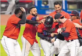  ?? TONY DEJAK/ASSOCIATED PRESS ?? Cleveland’s Jordan Luplow, center, is mobbed by teammates after hitting a walkoff, solo home run in the bottom of the ninth inning Wednesday, lifting Cleveland over the visiting Chicago White Sox.