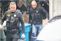  ?? Noah Berger / Associated Press ?? Officers carry evidence bags from the family home of Gilroy Garlic Festival shooter Santino Legan, who was shot dead by police after killing three people.