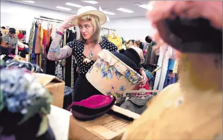  ?? Photograph­s by Christina House For The Times ?? THERESA GARCIA of Seal Beach tries on a hat at Goodwill Southern California’s Community Enrichment Center in Glassell Park.