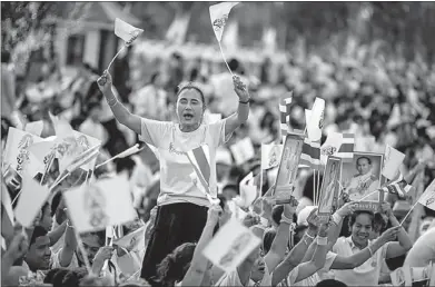  ?? ATHIT PERAWOGMET­HA / REUTERS ?? Well-wishers hold pictures of Thai King Bhumibol Adulyadej and wave Thai national flags as they gather to celebrate his 86th birthday near Klai Kangwon Palace, Hua Hin, Prachuap Khiri Khan province, on Thursday.