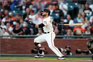  ?? Ezra Shaw / Getty Images /TNS (above); Lachlan Cunningham /
Getty Images /TNS (left) ?? Tommy La Stella (18, above) of the San Francisco Giants hits a lead-off home run against the San Diego Padres in the first inning at Oracle Park on Monday in San Francisco. Buster Posey (28, left) of the San Francisco Giants hits a solo home run in the bottom of the first inning.