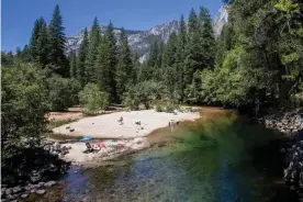  ??  ?? Visitors sunbathe on Fourth of July at Merced River in Yosemite national park, which is only admitting half of its normal number of daily visitors. Photograph: Apu Gomes/AFP/ Getty Images