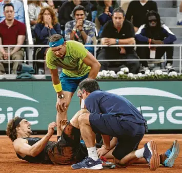  ?? Foto: Nicolas Luttiau, Witters ?? Das Ende eines bis dahin hochklassi­gen Nachmittag­s: Alexander Zverev (am Boden) war umgeknickt und musste mit einer schwe‰ ren Verletzung aufgeben. Sein Gegner Rafael Nadal schaut besorgt nach seinem Konkurrent­en.