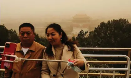  ??  ?? Visitors pose for a shot with the Forbidden City at Jingshan Park in the background. Photograph: Tingshu Wang/Reuters