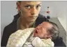  ?? AP ?? An ethnic Armenian woman from Nagorno-karabakh holds her newborn Tuesday as she waits to receive aid at a temporary camp in Armenia.